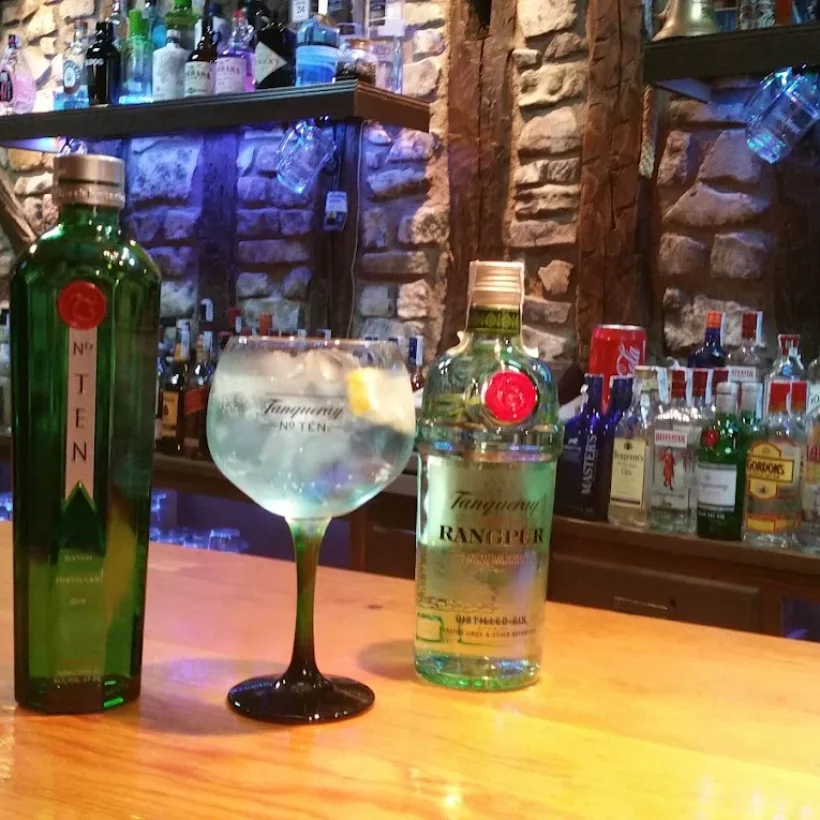 Dos botellas de alcohol y una copa en una barra